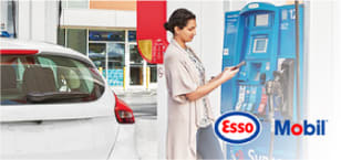 Photo of woman at gas station fuel dispenser, with Esso and Mobil logos